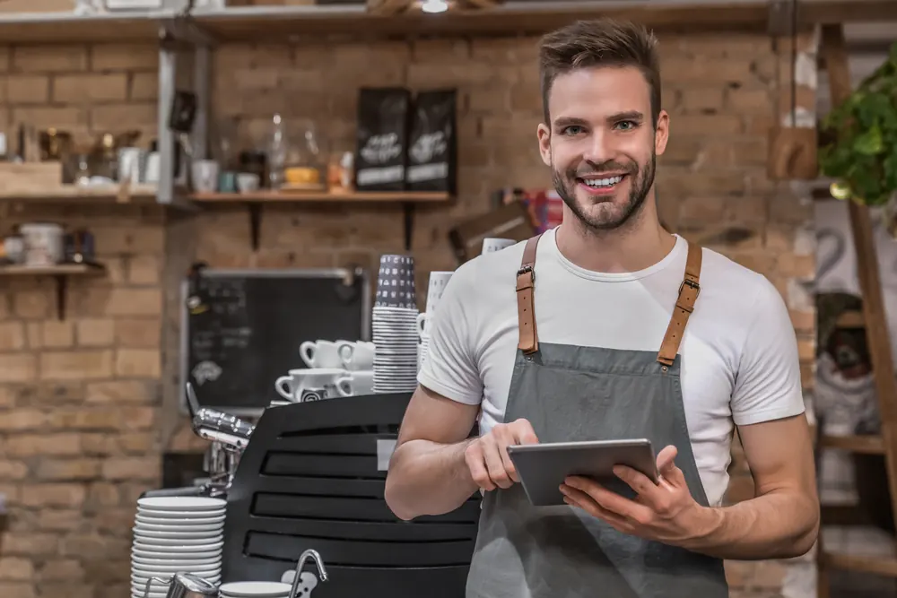 Responsable de una cafetería con una tablet en su local